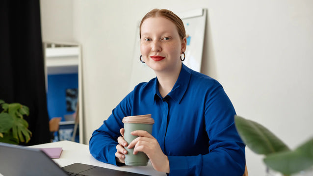 Nainen sinisessä paidassa kannettavan edessä
